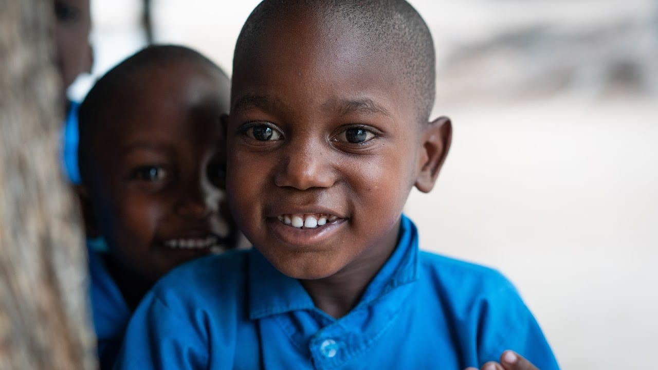 Two Kenyan children smile at school in Gede