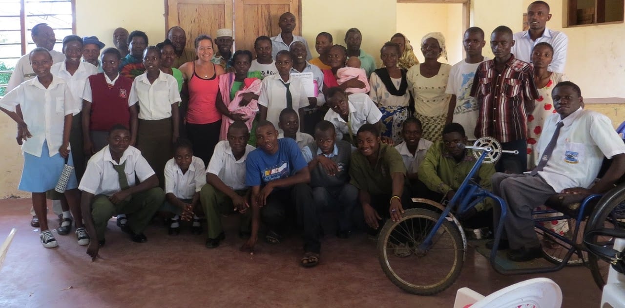 A group of about 40 Kenyans of various ages smiling at the camera.