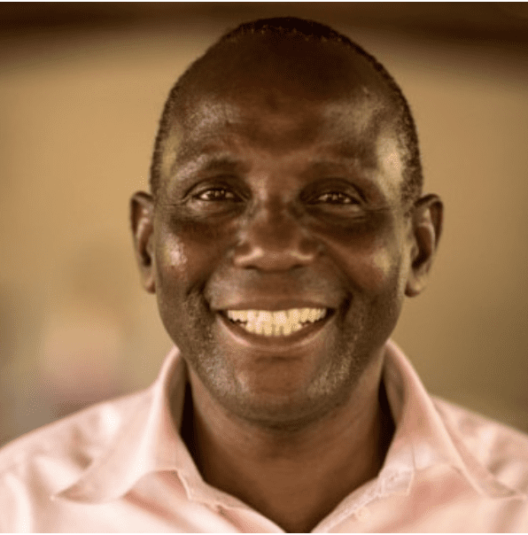 A Kenyan man wearing a pink shirt.