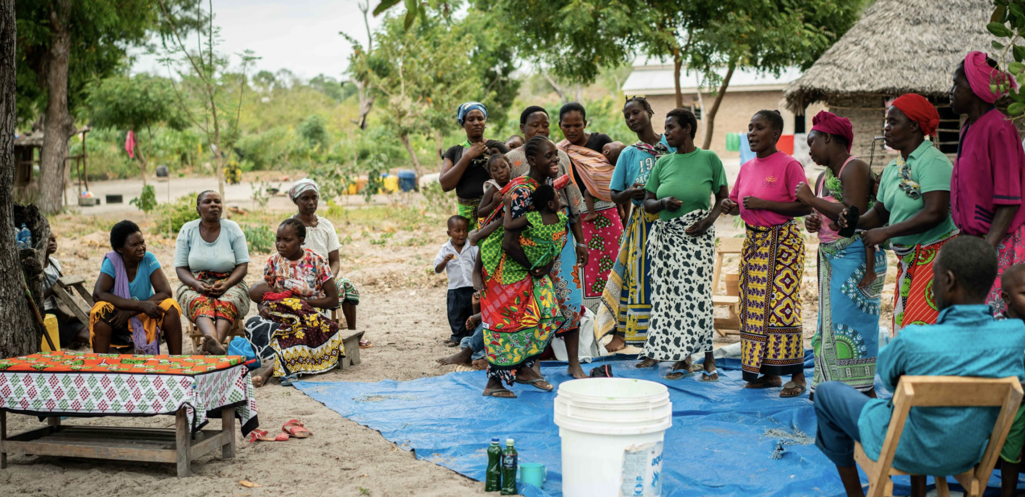 9 Kenyan woman standing before a group of listeners.