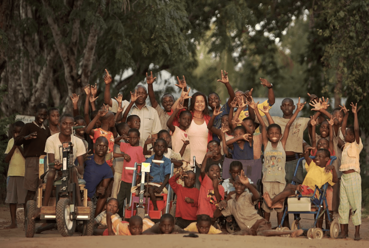 38 children and two adults holding their hands in the air.