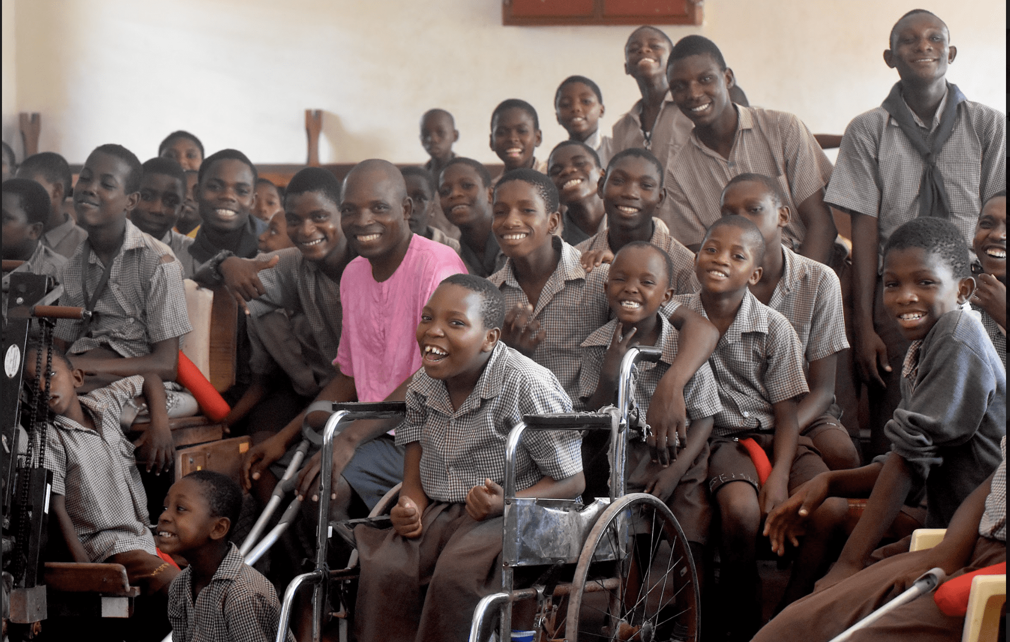 A group of Kenyan school boys seated together and smiling.