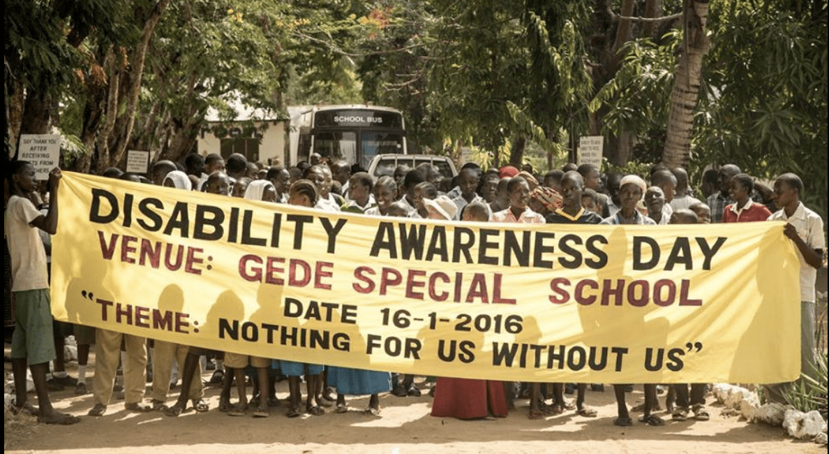 A large group of school children holding a banner that reads "Disability Awareness Day"