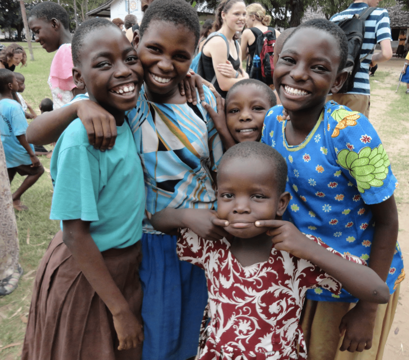 Five children hugging each other and smiling.