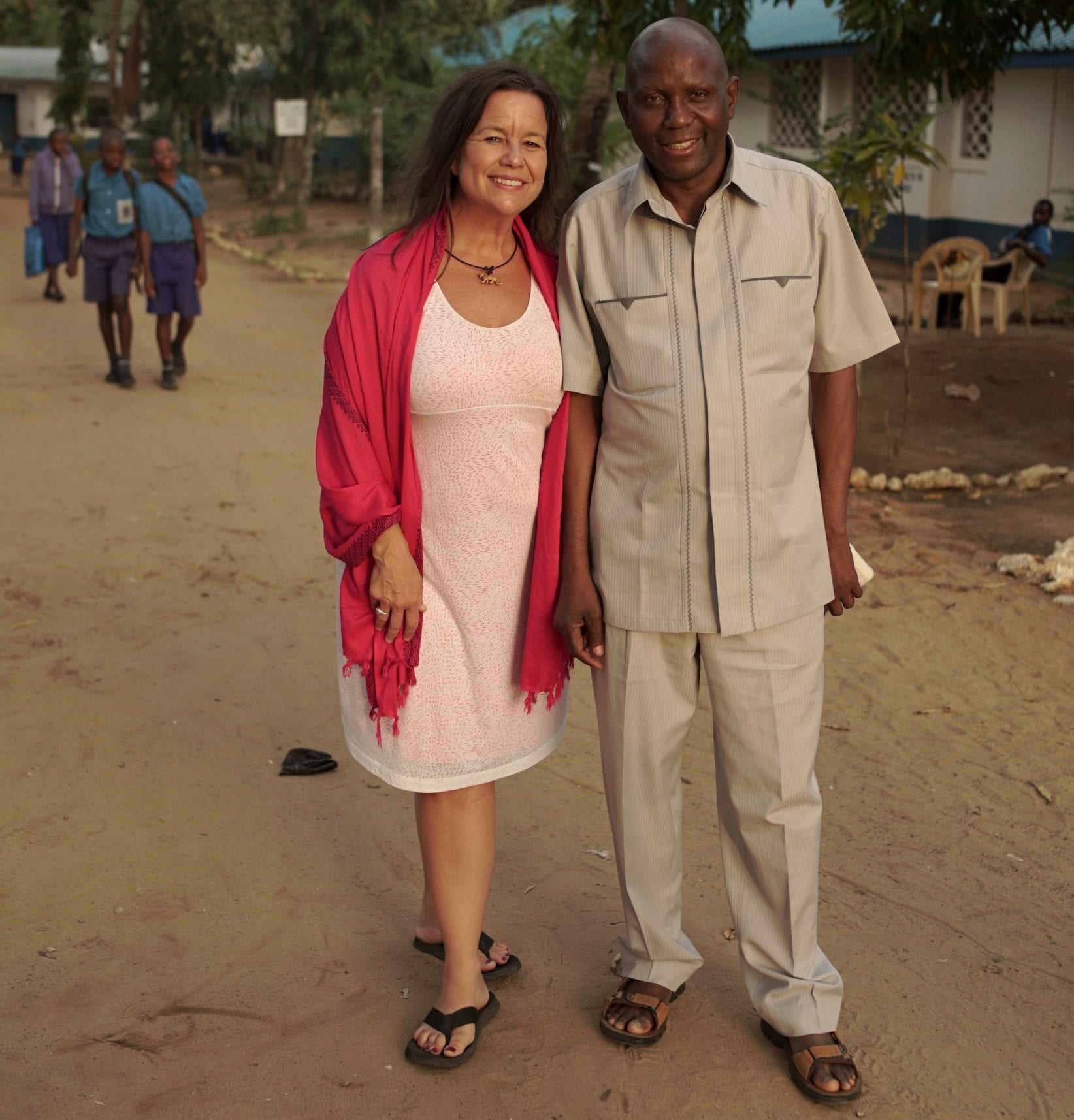 An adult man and woman standing beside each other outside.