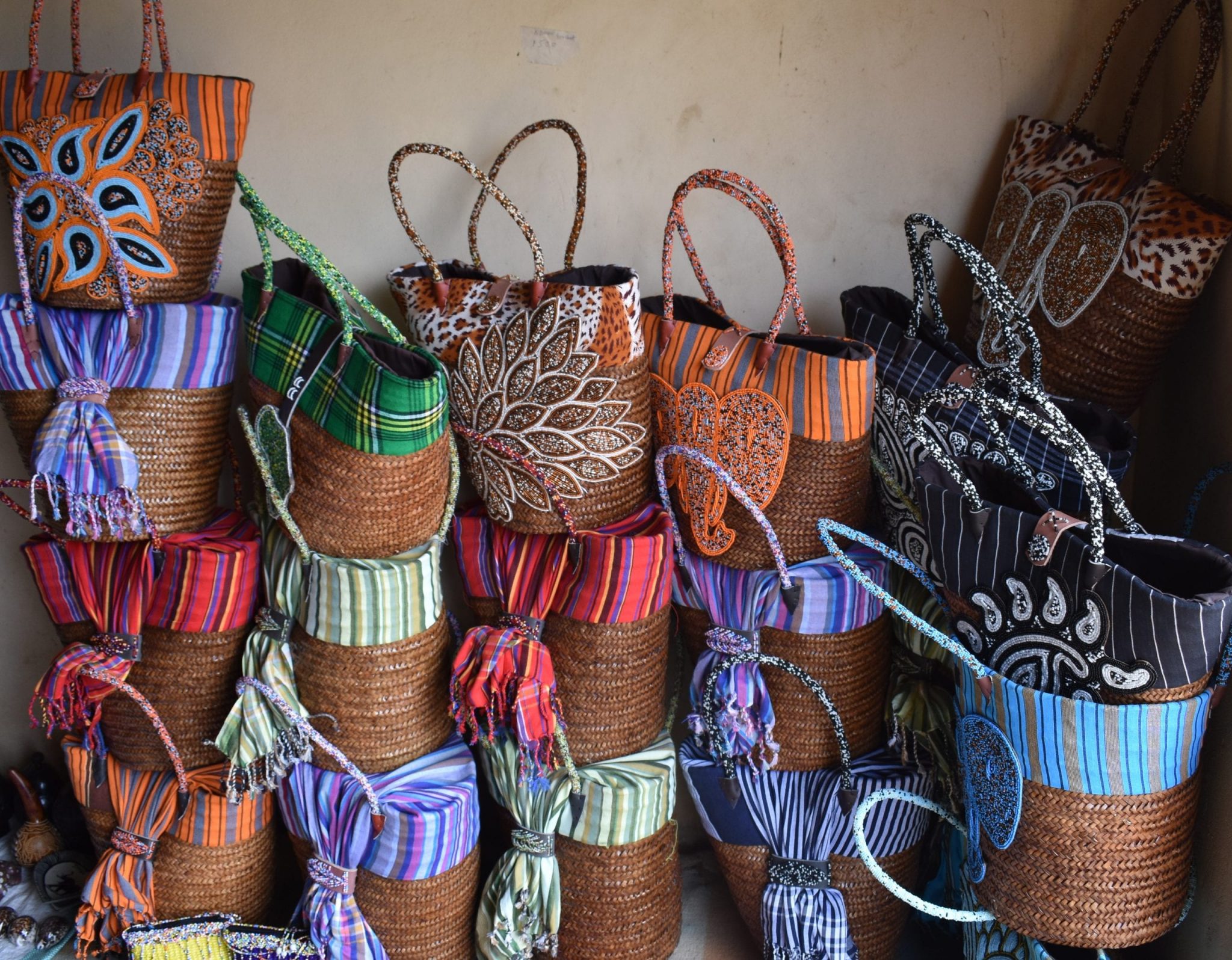 17 wicker baskets stacked against a wall.