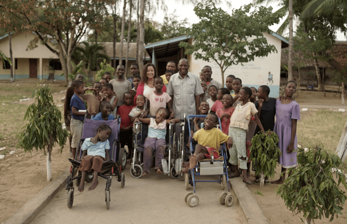 Cindy and Leonard standing with large group of children apart of Kupenda's programs.