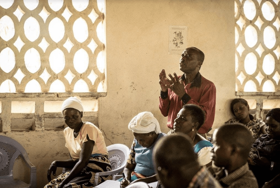 Man standing to share his story at Kupenda’s Abuse Prevention Workshop, surrounded by other audience members.