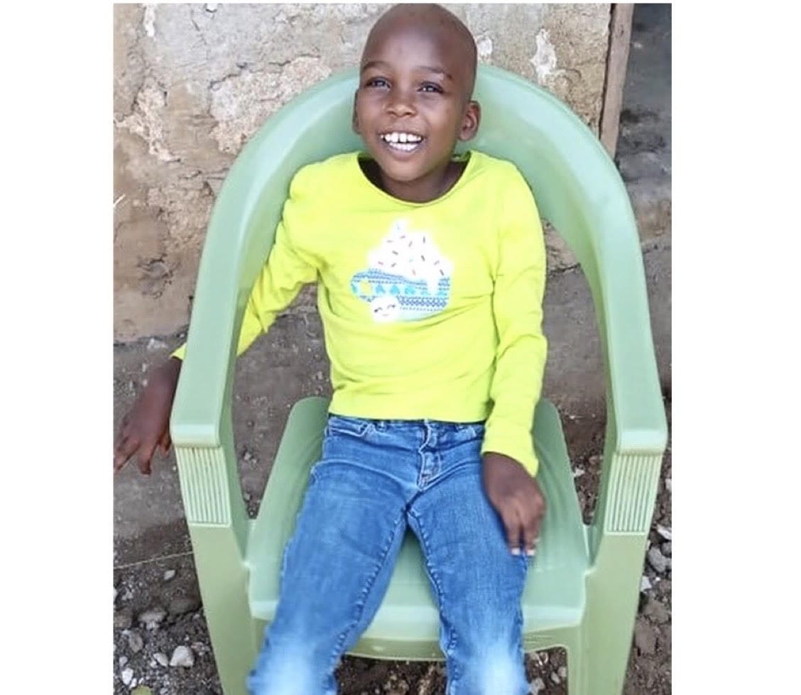 Valentine- smiling young girl sitting in a green chair, wearing a bright yellow shirt.