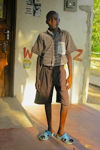 Kenyan teen, Amani Patrick, standing outside of a building