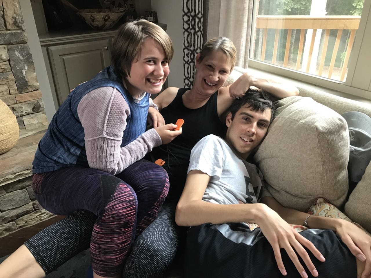 A mom and two of her children laying on a couch