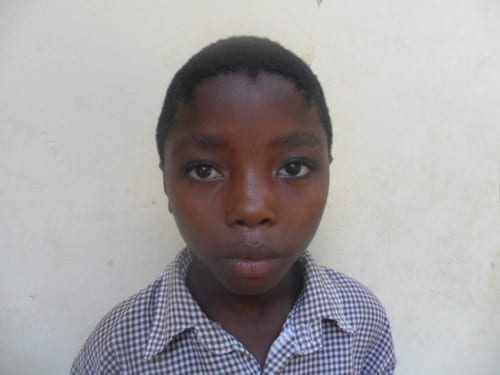 Young boy wearing a blue shirt looking at the camera