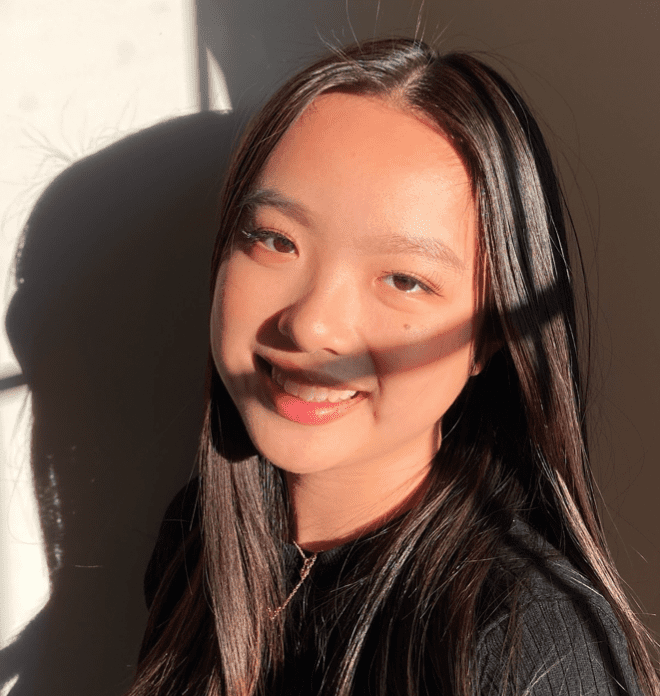 A young woman in a black shirt smiling