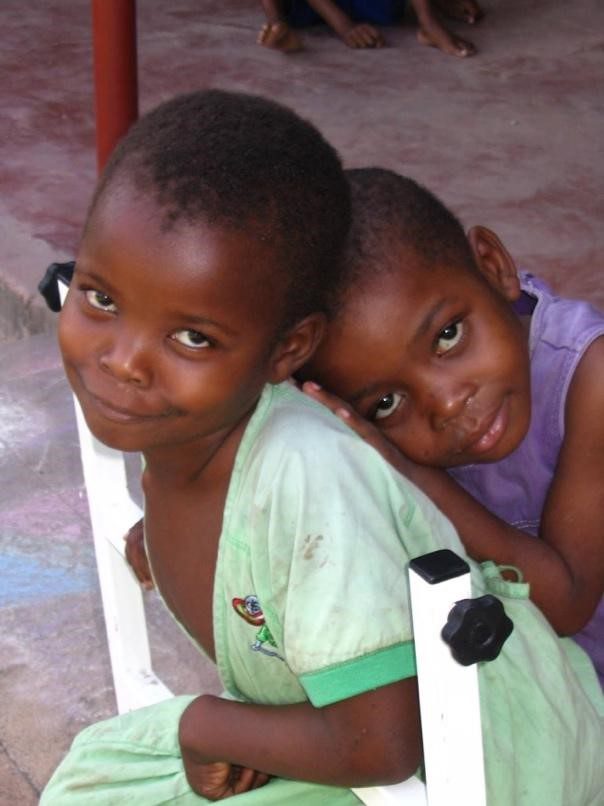 Two children pictured one in a green dress and one in a purple shirt