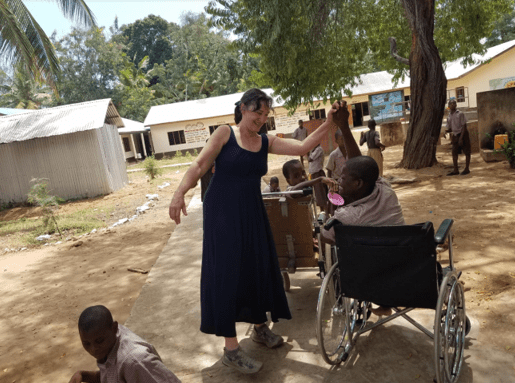 Emily Morrison high-fiving a man in a wheelchair