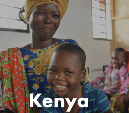 A woman in a colorful headscarf and dress smiling with a child in front of her, both looking happy. Kenya written on the screen